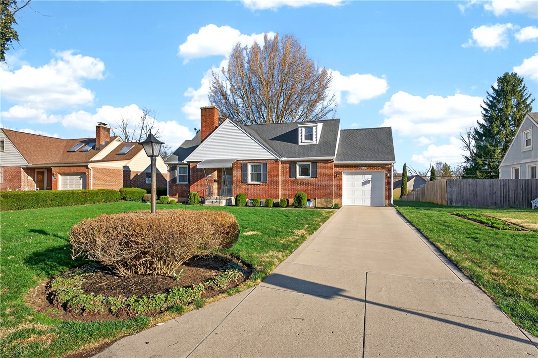 1237 Laurelwood Road Dayton, OH 45409 - Photo 3 of 56 This charming residence features a brick exterior, a well-maintained lawn, and an attached garage.