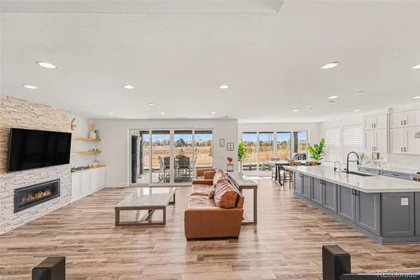 a large white kitchen with wooden floor and a sink