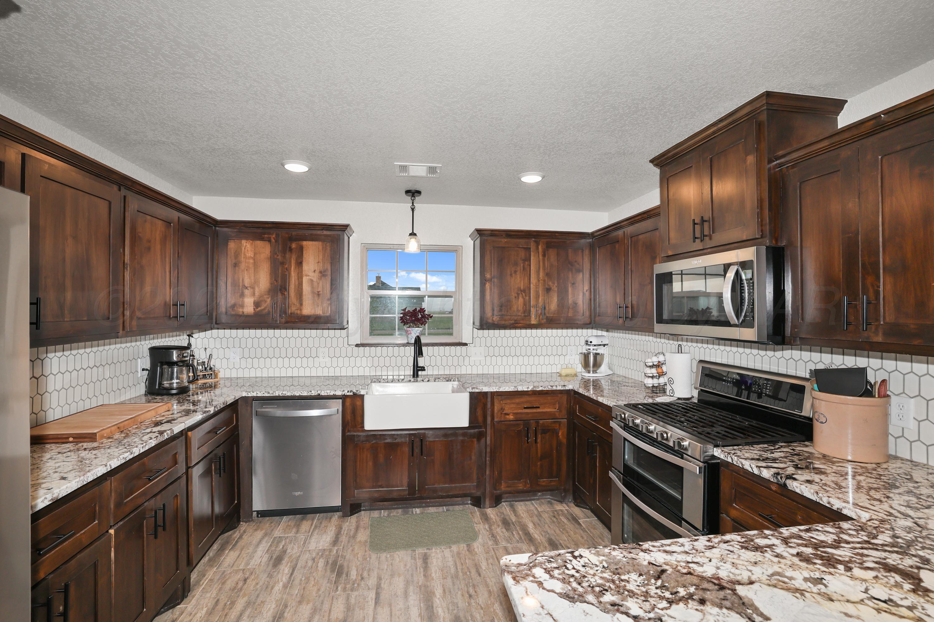 17450 Stone Creek Road Amarillo, TX 79124 - Photo 12 of 30 a kitchen with stainless steel appliances kitchen island granite countertop a sink stove and refrigerator
