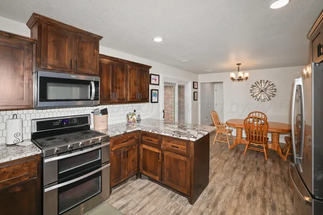 a kitchen with wooden cabinets and stainless steel appliances