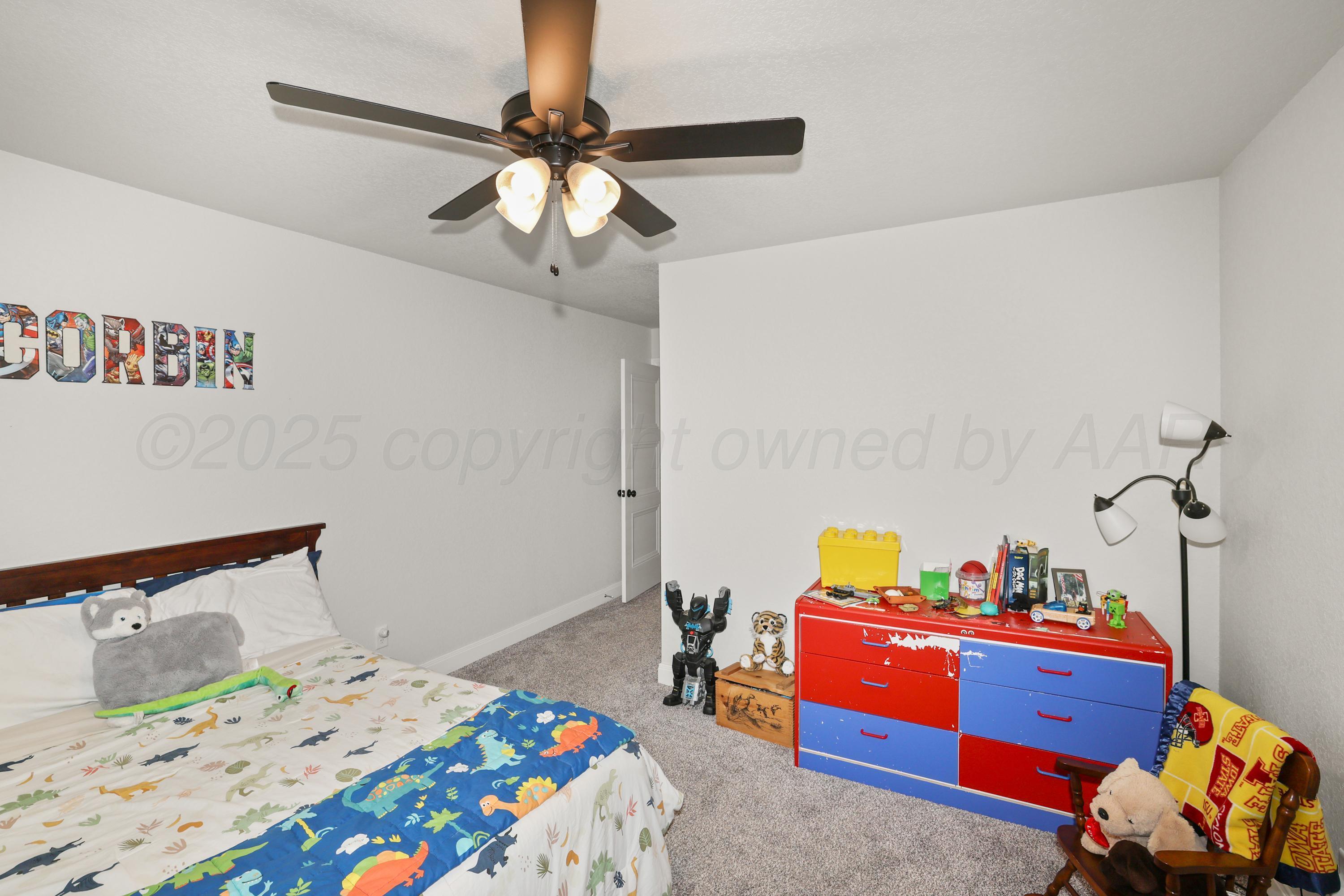 17450 Stone Creek Road Amarillo, TX 79124 - Photo 20 of 30 a bedroom with a bed and a chandelier