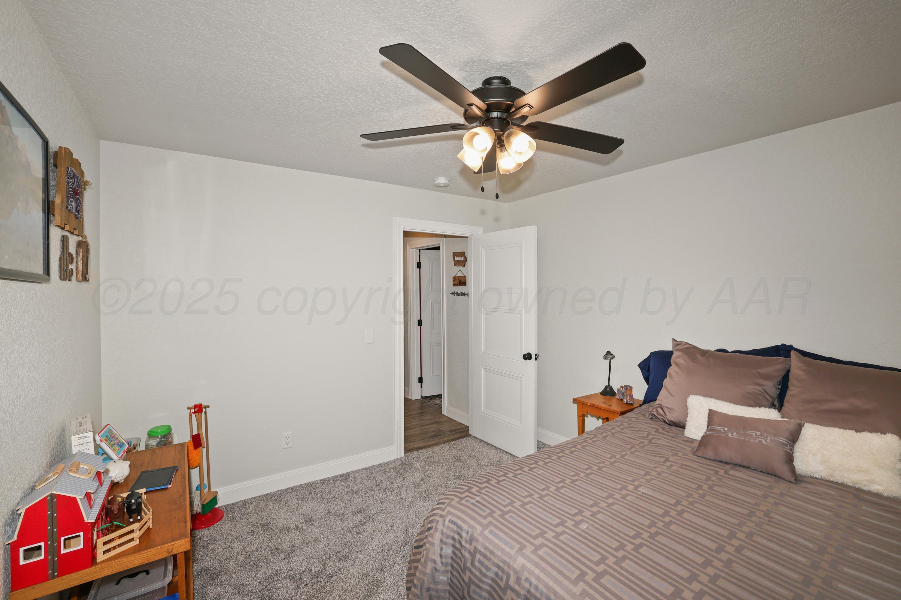 17450 Stone Creek Road Amarillo, TX 79124 - Photo 22 of 30 a bedroom with a bed and a chandelier