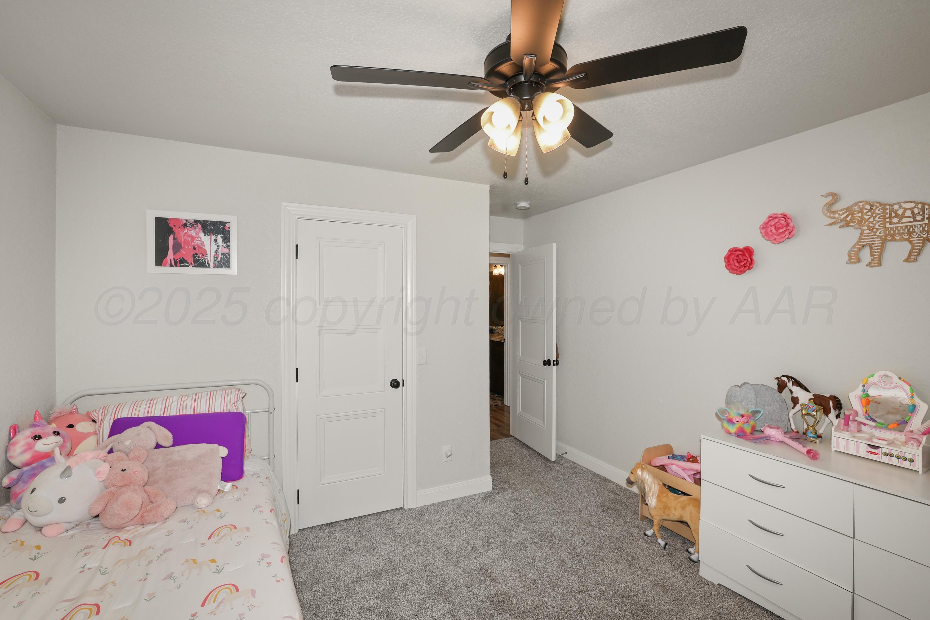 17450 Stone Creek Road Amarillo, TX 79124 - Photo 24 of 30 a bedroom with a bed and a chandelier