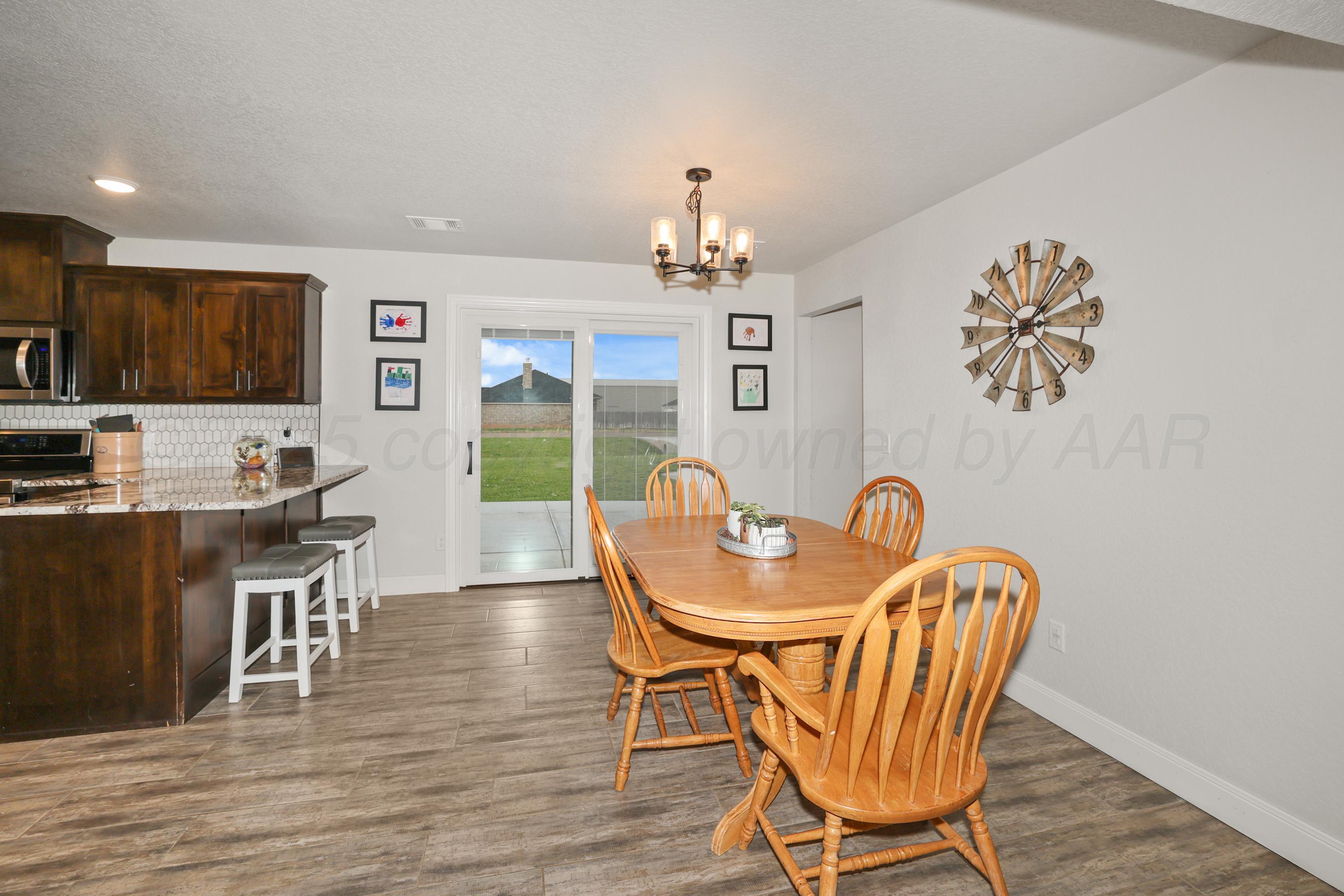 17450 Stone Creek Road Amarillo, TX 79124 - Photo 9 of 30 a view of a dining room with furniture and wooden floor