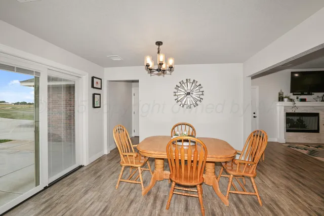 a dining room with furniture a chandelier and wooden floor