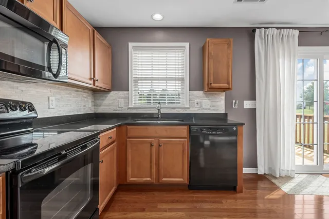 a kitchen with stainless steel appliances granite countertop a sink stove and microwave