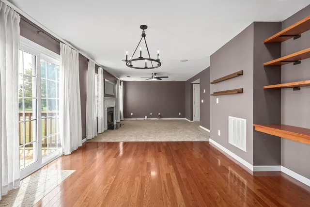 a very nice looking room with wooden floor and windows