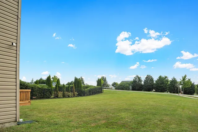 a view of a house with a backyard and trees