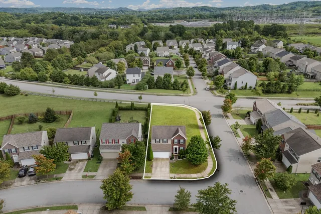 an aerial view of a house with a garden and a mountain view
