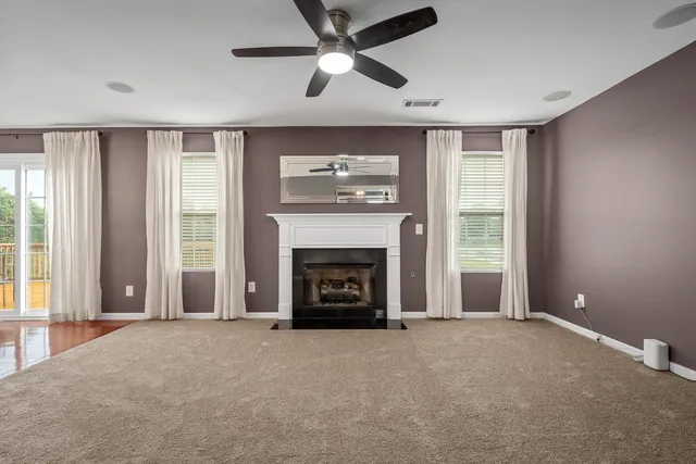 a view of an empty room with window and fire place
