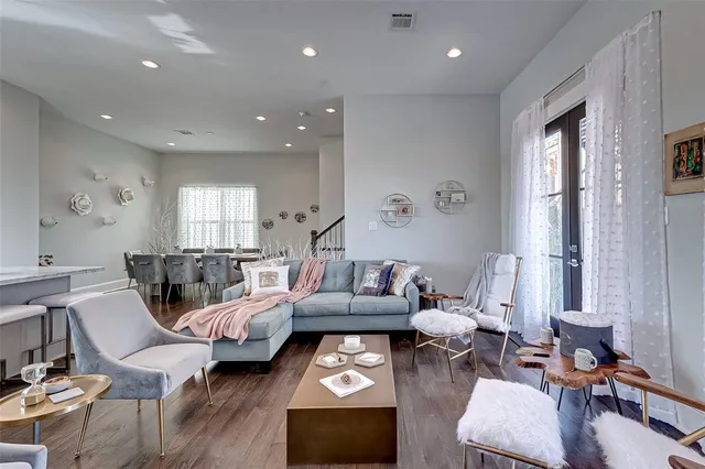 a living room with furniture wooden floor and a large window