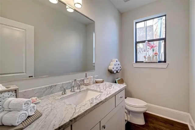 a en suite bathroom with a granite countertop sink and a mirror