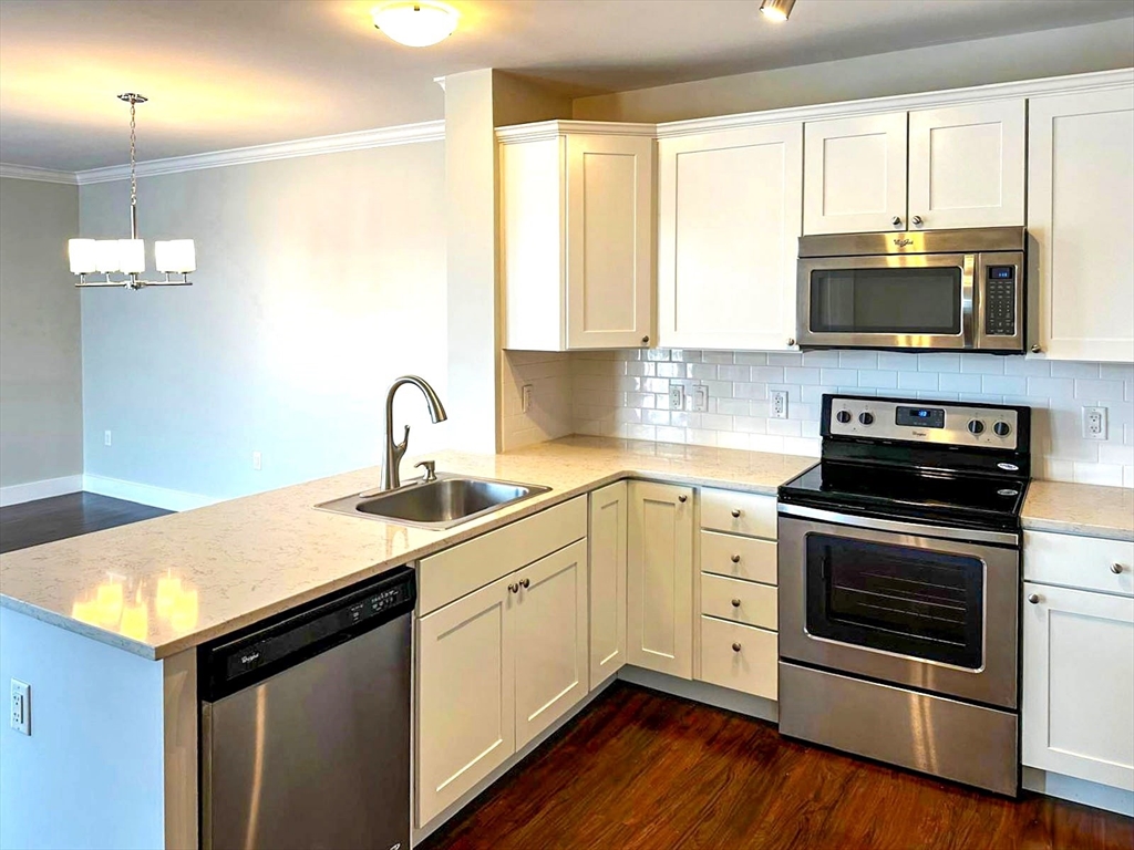 978 Worcester Street, Unit 310 Wellesley, MA 02482 - Photo 8 of 8 a kitchen with a sink stove and microwave
