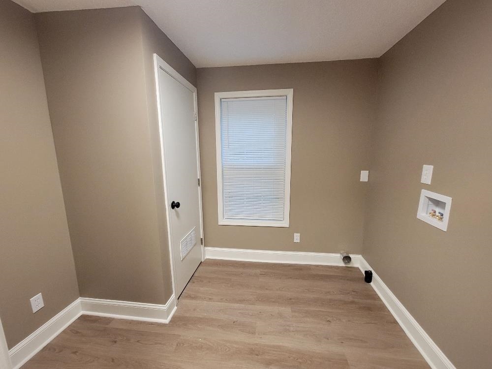 913 Chambliss Road Memphis, TN 38116 - Photo 9 of 16 Utility room featuring wood-finish flooring, neutral wall tones, white trim, and a window with blinds