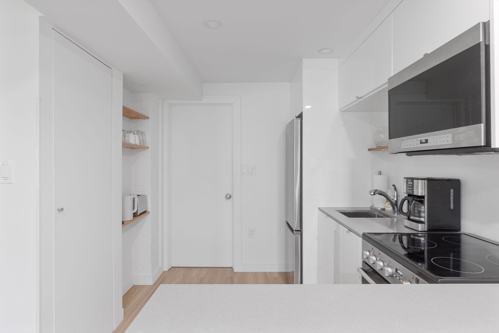 99 Upland Road Cambridge, MA 02140 - Photo 4 of 16 a kitchen with a sink and a stove top oven with wooden floor