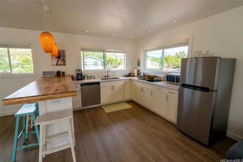 a kitchen with granite countertop a sink appliances a window and a counter top space