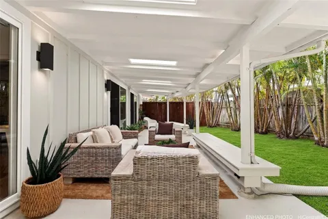 a living room with patio furniture and a garden
