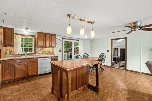 a open kitchen with stainless steel appliances granite countertop a sink a stove and refrigerator