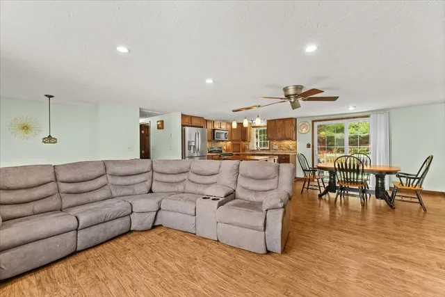 a living room with furniture wooden floor and dining table