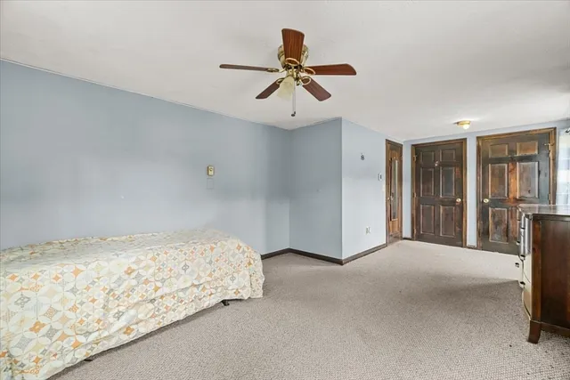 a bedroom with a large bed chandelier and a window