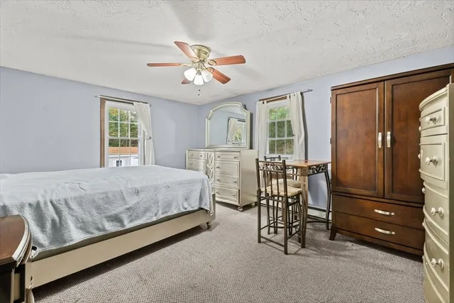 a bedroom with a bed a chandelier and dresser