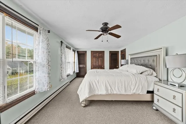 a spacious bedroom with a large bed and a chandelier fan
