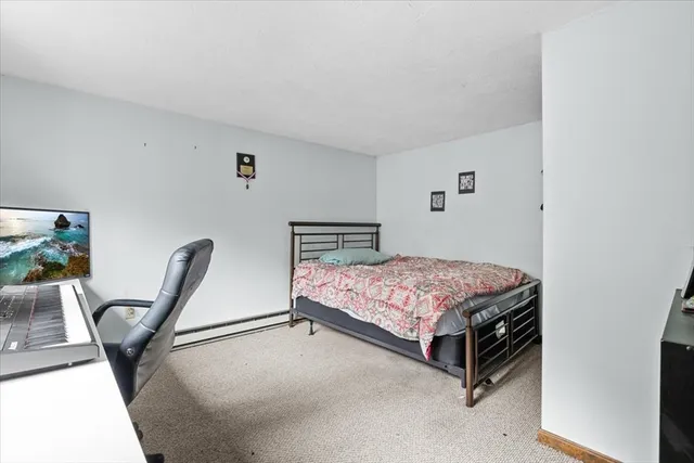 a bedroom with a bed a chair and potted plant on the table
