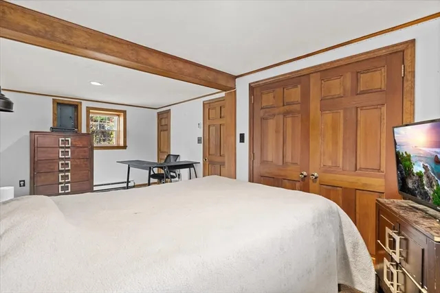 a bedroom with a bed and dresser with chair