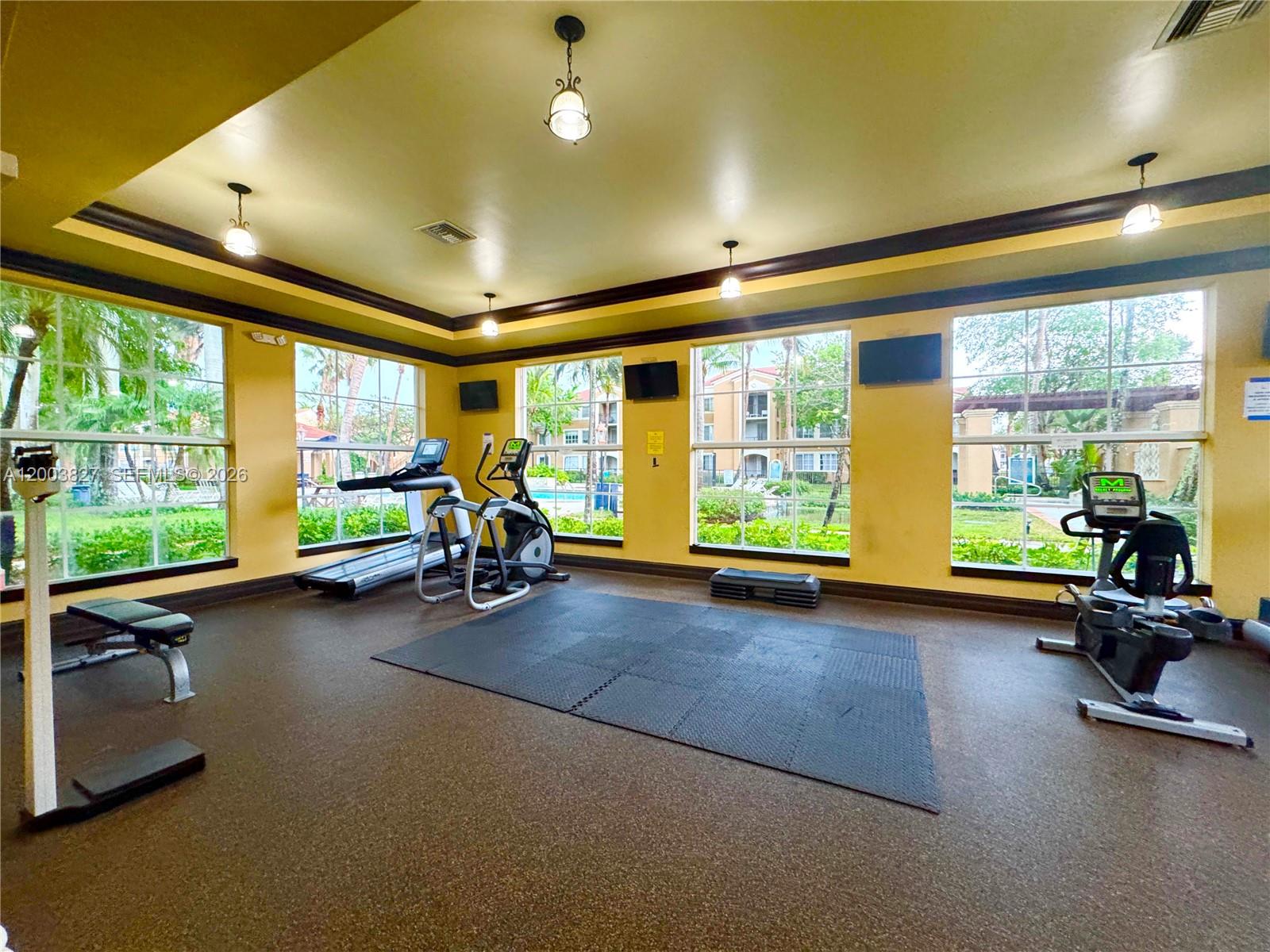 8060 North Nob Hill Road, Unit 203 Tamarac, FL 33321 - Photo 25 of 69 a room with gym equipment and large windows