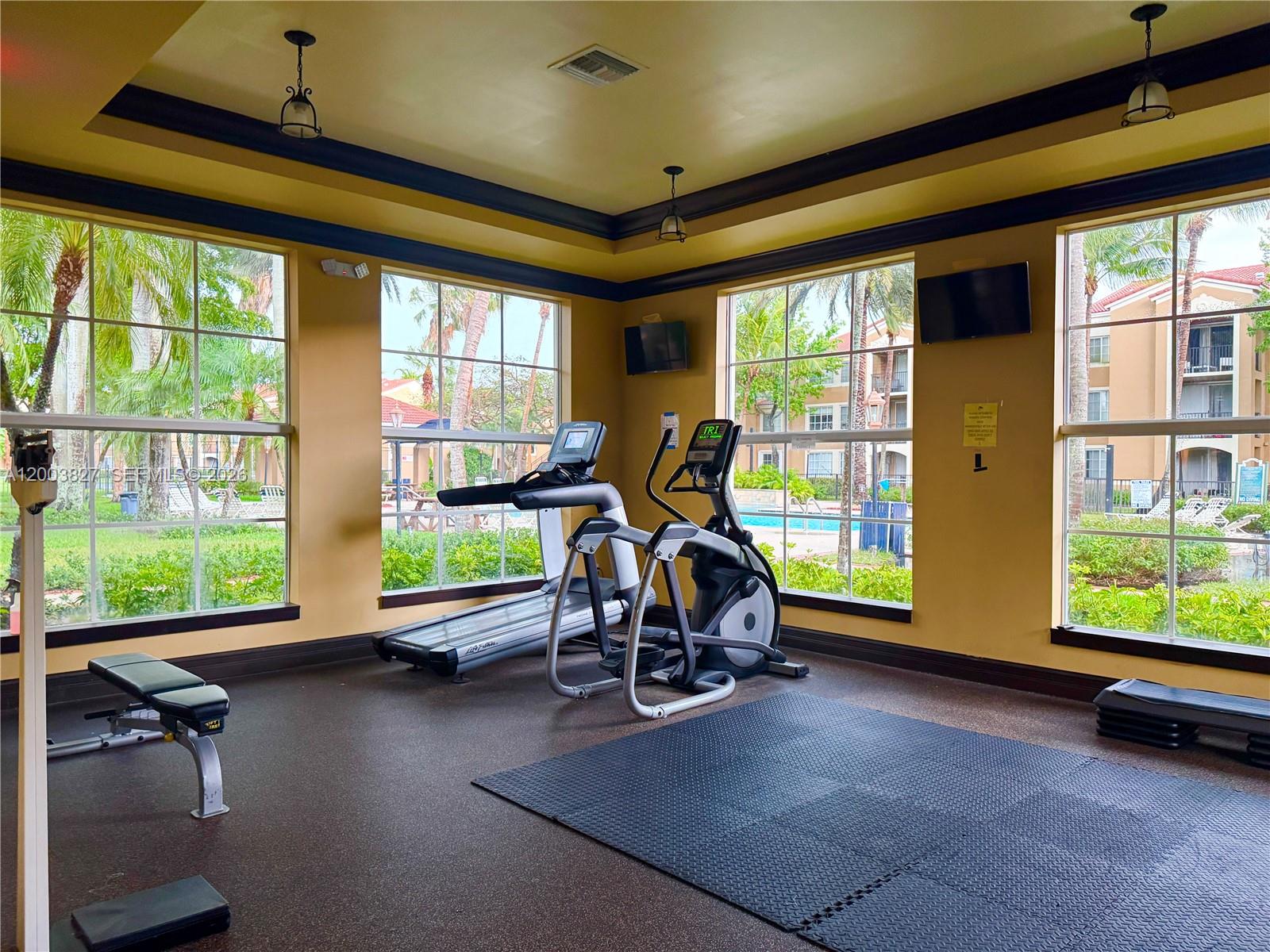 8060 North Nob Hill Road, Unit 203 Tamarac, FL 33321 - Photo 41 of 69 a view of a room with gym equipment and large windows