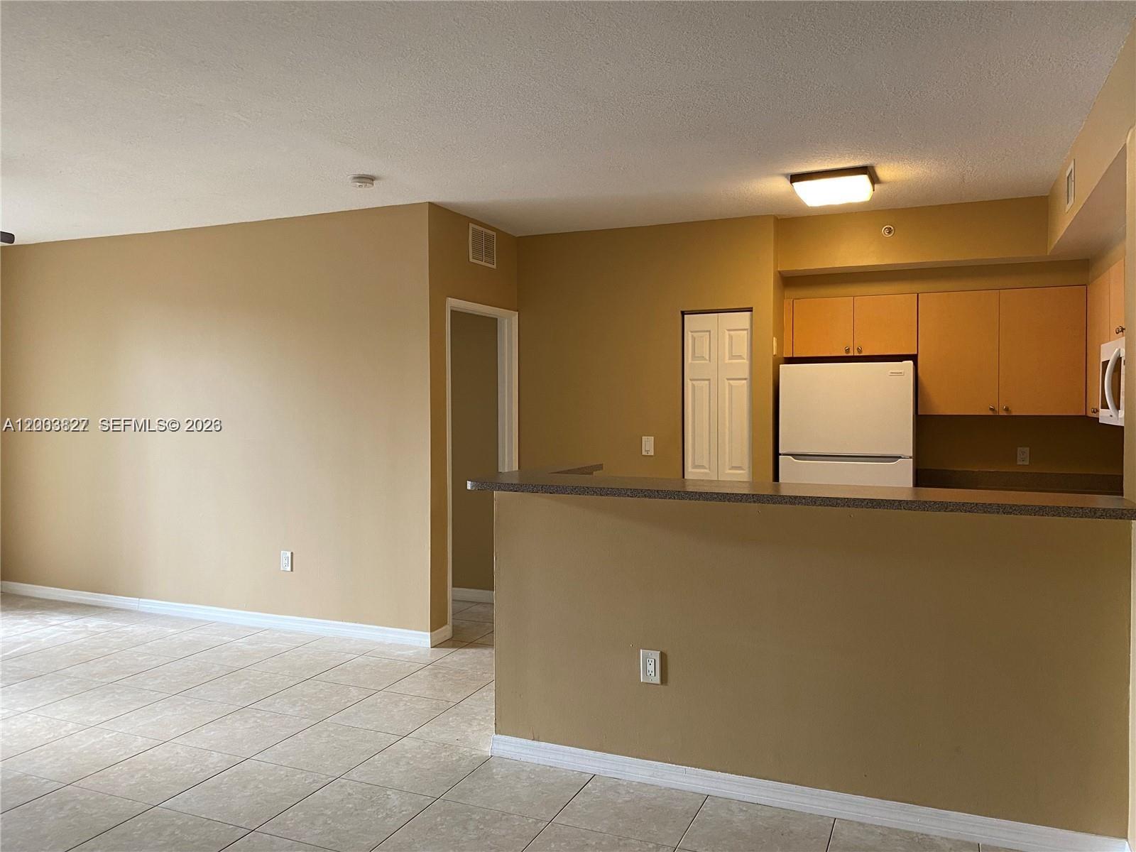 8060 North Nob Hill Road, Unit 203 Tamarac, FL 33321 - Photo 5 of 69 a view of a kitchen with a fridge