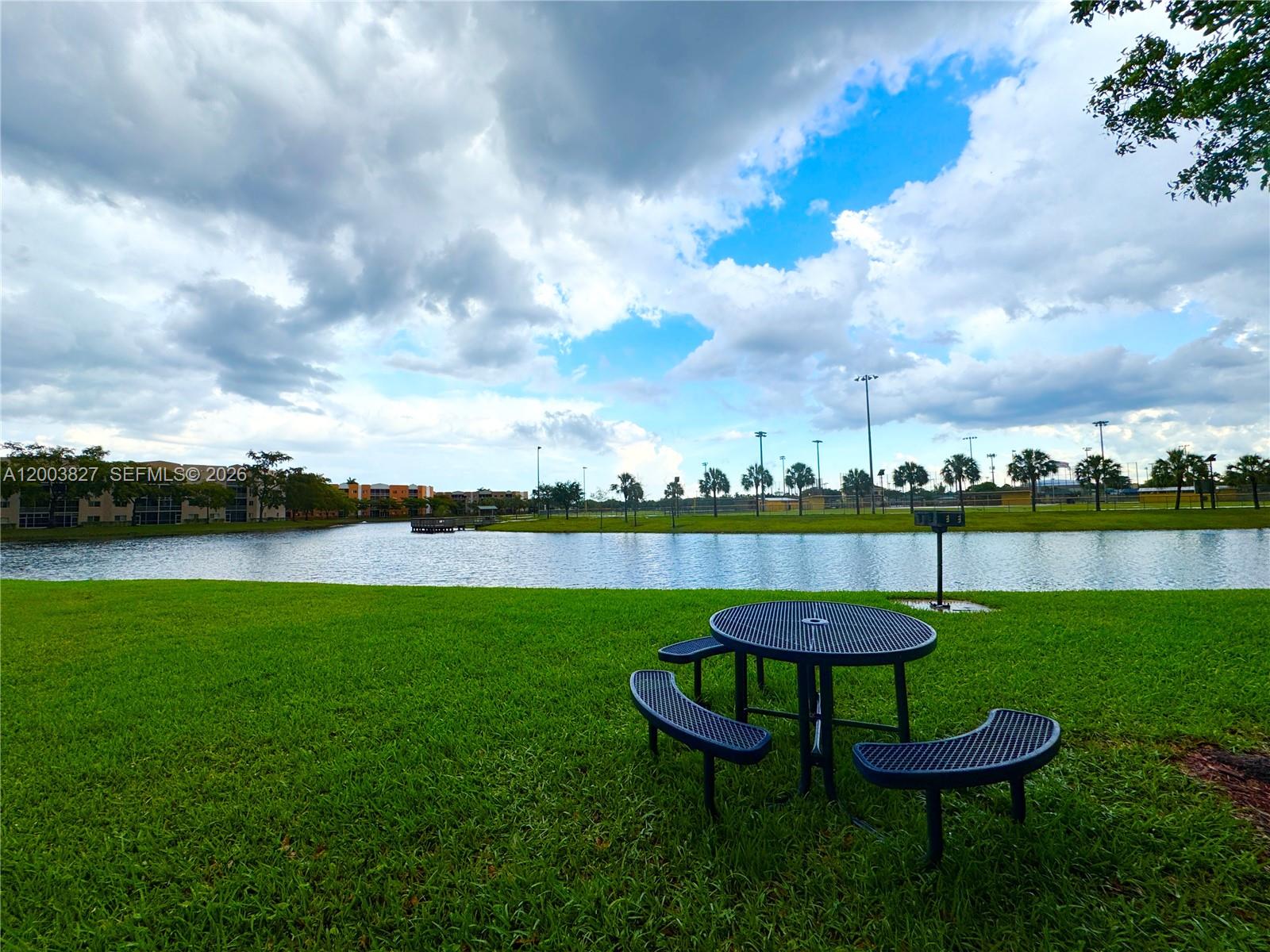 8060 North Nob Hill Road, Unit 203 Tamarac, FL 33321 - Photo 69 of 69 a view of a lake with a yard table and chairs