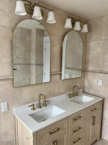 a bathroom with a double vanity sink and a mirror