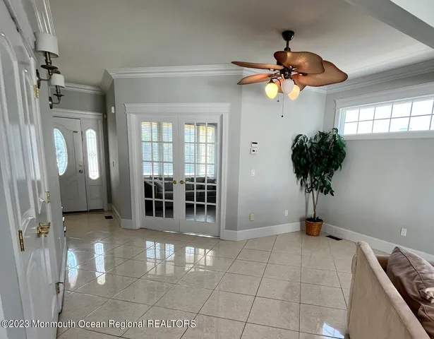 a view of a room with a chandelier fan and windows