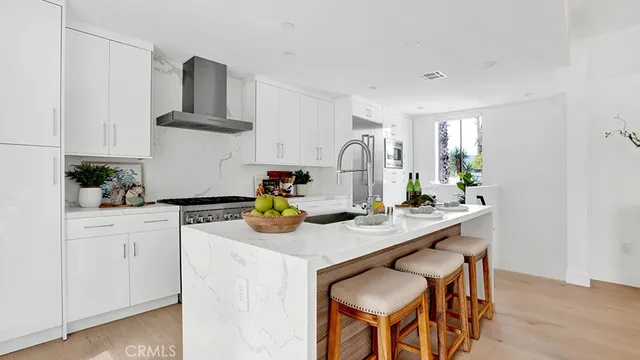 a kitchen with stainless steel appliances granite countertop a sink white cabinets and a refrigerator