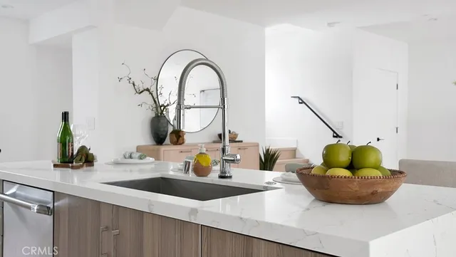 a kitchen with a sink a counter and chairs