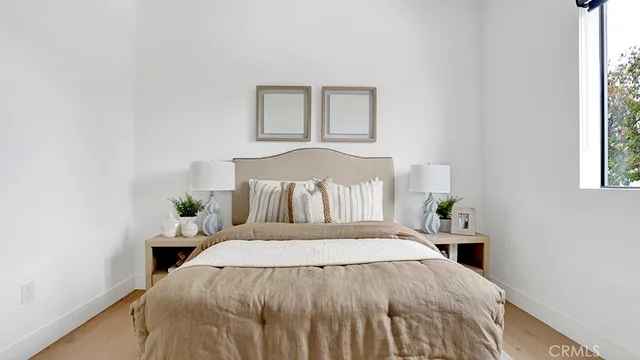 a bed sitting in a bedroom next to a window and a lamp