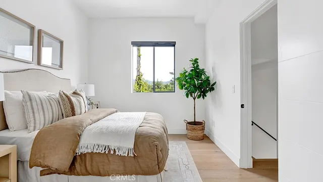 a bedroom with a bed and a potted plant