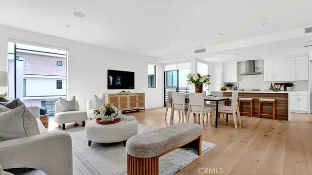 a living room with furniture a flat screen tv and kitchen view