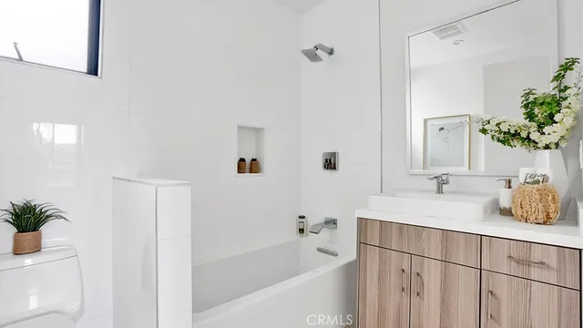 a bathroom with a tub sink and mirror