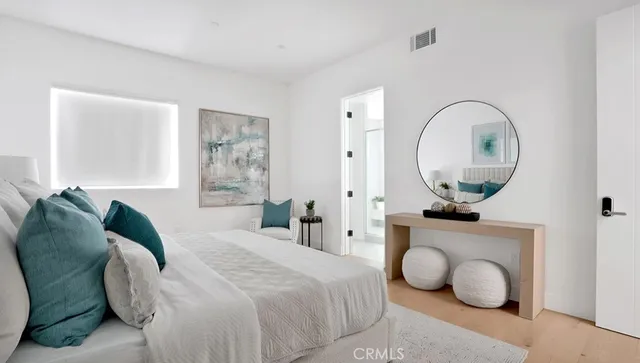 a bedroom with a bed and a painting on the wall