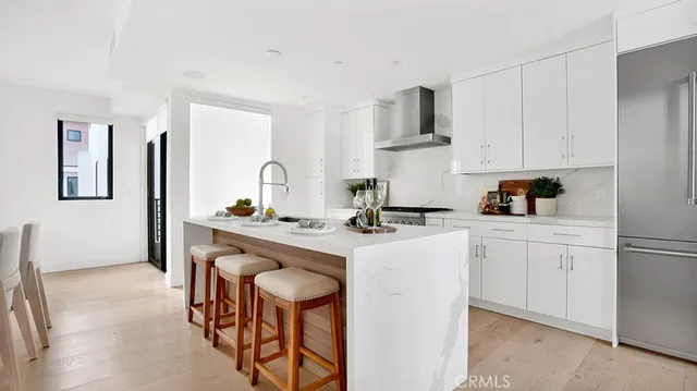 a kitchen with stainless steel appliances a sink a stove a refrigerator and cabinets