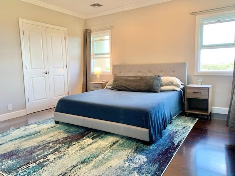 80 Koani Loop Wailuku, HI 96793 - Photo 12 of 18 a bedroom with a bed a table and wooden floor