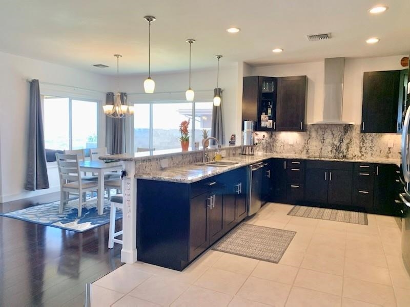 80 Koani Loop Wailuku, HI 96793 - Photo 7 of 18 a bathroom with a granite countertop sink and a large mirror