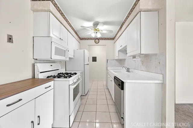 a kitchen with stainless steel appliances a stove a sink and white cabinets