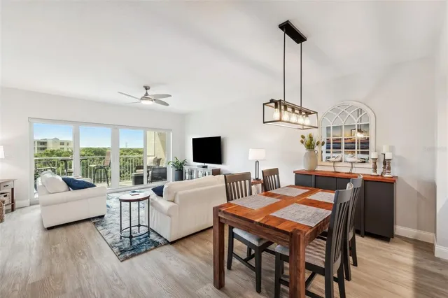 a living room with furniture a flat screen tv and a large window
