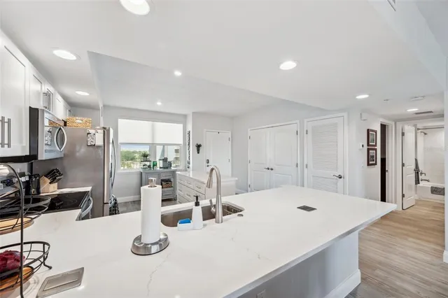 a large white kitchen with a large window
