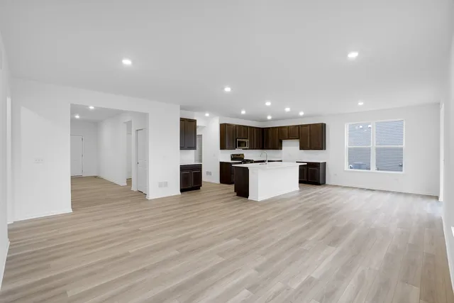 a view of kitchen with granite countertop cabinets and refrigerator
