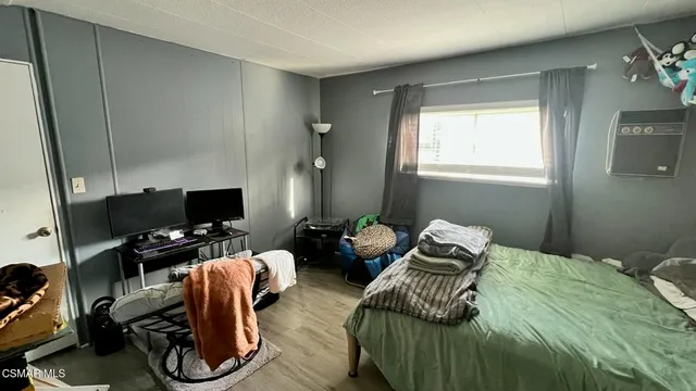 a bedroom with a bed and a computer on the desk