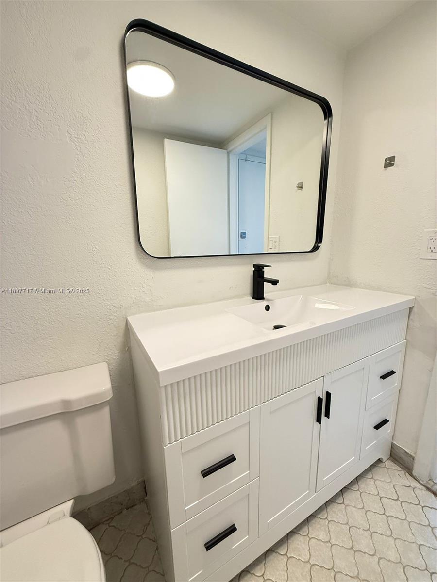 13499 Biscayne Boulevard, Unit 811 North Miami, FL 33181 - Photo 3 of 20 a bathroom with a sink a mirror and a toilet